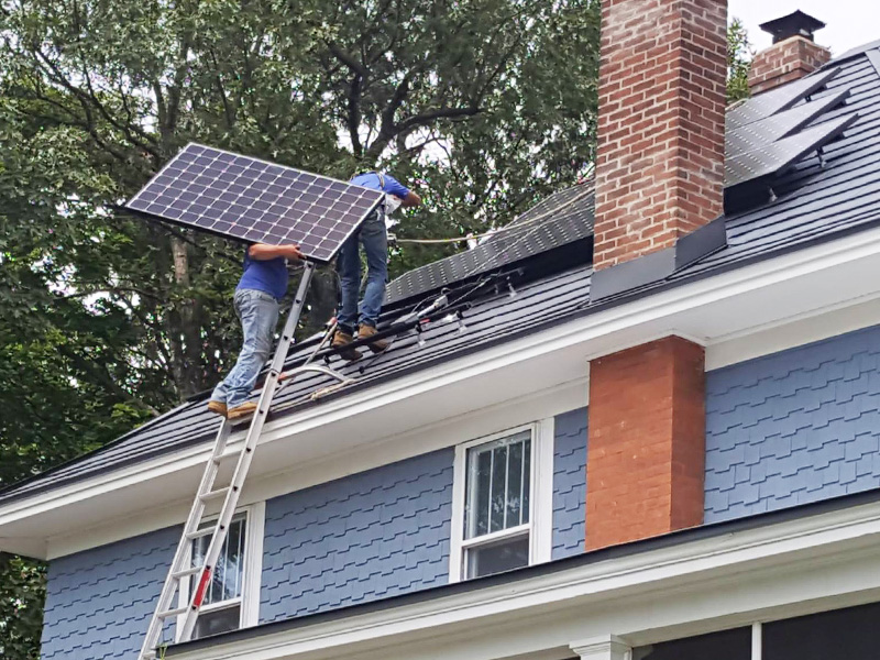 clean energy installers working on metal roof